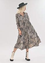 Load image into Gallery viewer, The Audrey dress is a lesson in edgy femininity with soft lines in a bold print.  Maxi length with full length sleeves and ruffle sleeve detail, with a collar and button down to the empire waist line.  Crafted from soft 100% Rayon, in a gorgeous zebra style print in black against cream, it really will be a long term favourite.
