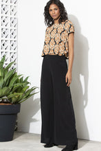 Load image into Gallery viewer, Made for effortless elegance, these Rayon Mar tailored wide leg trousers in black will take you effortlessly from desk to dinner !  Lightweight with an elegant high waist, these pants feature 2 front pockets and a flattering tailored fit.  The high waist lengthens the silhouette and the lightweight fabric is both comfortable and cool and floats elegantly with every move.  Wear with a silk blouse to the office or with an off the should top and jacket,
