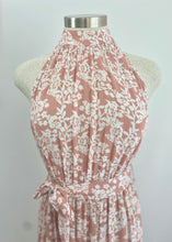 Load image into Gallery viewer, The stunning Amanda Floral Maxi in a gorgeous white floral print against a soft Blush pink background.  The long loose flowing skirt is tiered and belted at the waist. The halter neck is button at the back creating a shape that is very flattering.  The soft Poly Cotton fabric is lightweight and cool, perfect for a relaxed lunch with friends or an evening stroll along the beach.
