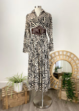 Load image into Gallery viewer, The Audrey dress is a lesson in edgy femininity with soft lines in a bold print.  Maxi length with full length sleeves and ruffle sleeve detail, with a collar and button down to the empire waist line.  Crafted from soft 100% Rayon, in a gorgeous zebra style print in black against cream, it really will be a long term favourite.
