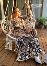 Load image into Gallery viewer, The Audrey dress is a lesson in edgy femininity with soft lines in a bold print.  Maxi length with full length sleeves and ruffle sleeve detail, with a collar and button down to the empire waist line.  Crafted from soft 100% Rayon, in a gorgeous zebra style print in black against cream, it really will be a long term favourite.

