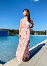 Load image into Gallery viewer, The stunning Amanda Floral Maxi in a gorgeous white floral print against a soft Blush pink background.  The long loose flowing skirt is tiered and belted at the waist. The halter neck is button at the back creating a shape that is very flattering.  The soft Poly Cotton fabric is lightweight and cool, perfect for a relaxed lunch with friends or an evening stroll along the beach.
