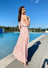 Load image into Gallery viewer, The stunning Amanda Floral Maxi in a gorgeous white floral print against a soft Blush pink background.  The long loose flowing skirt is tiered and belted at the waist. The halter neck is button at the back creating a shape that is very flattering.  The soft Poly Cotton fabric is lightweight and cool, perfect for a relaxed lunch with friends or an evening stroll along the beach.
