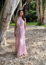 Load image into Gallery viewer, The stunning Amanda Floral Maxi in a gorgeous white floral print against a soft Blush pink background.  The long loose flowing skirt is tiered and belted at the waist. The halter neck is button at the back creating a shape that is very flattering.  The soft Poly Cotton fabric is lightweight and cool, perfect for a relaxed lunch with friends or an evening stroll along the beach.
