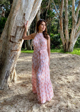 Load image into Gallery viewer, The stunning Amanda Floral Maxi in a gorgeous white floral print against a soft Blush pink background.  The long loose flowing skirt is tiered and belted at the waist. The halter neck is button at the back creating a shape that is very flattering.  The soft Poly Cotton fabric is lightweight and cool, perfect for a relaxed lunch with friends or an evening stroll along the beach.

