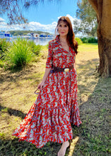 Load image into Gallery viewer, The Skye Maxi shirt dress is a gorgeous full length maxi dress, featuring a wide tiered section at the hem and side slits either side.  With a stylish shirt collar, buttoned to the chest with a seam under the bust and 3/4 cuffed sleeves. The skirt has generous volume with so much fabric, which is soft and floaty in a gorgeous red floral print.  Can be worn belted or loose with pockets

