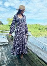 Load image into Gallery viewer, The Elle Maxi will make you feel a million dollars!  Perfect for any social occasion, but also great for work.  With a full skirt and a plunging frill neckline in a beautiful soft pink, beige and aubergine floral print against black.  It features a super flattering design with a v-neck front, empire waist, 3 tiered ruffled hem, a side zip and elegant bell sleeves.  In a gorgeous soft Rayon, it is breast-feeding friendly with buttons at the front and is super quick and easy to feed your babe
