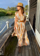 Load image into Gallery viewer, The Emily Dress by Caro, in a gorgeous print of earthy tones that represent the colours of outback Australia. The soft 100% Rayon fabric is lightweight and cool, and the loose flowing skirt has a pretty oversized tier.  it is buttoned down the front so can be worn open layered over shorts, jeans or buttoned up as a dress.  Delicate cap sleeves, a gathered waist and a V neckline create a flattering silhouette, and pockets give it a relaxed feel. 
