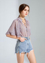 Load image into Gallery viewer, GDS Rina Blouse - a colourful tonal print in lilac, with pretty ruffled details on the wide bell sleeves and around the neck create a very feminine look.  Buttoned down the front with a tie at the neck this blouse is a real statement piece and looks stunning worn with just about anything, perfect with jeans when you want to look classy but keep it casual, or with tailored trousers or a skirt for a more formal look. 
