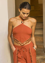 Load image into Gallery viewer, A sassy bohemian style halter top, with a tie back, and tassel trim in deep burnt orange colour.   The halter top has a feature ring detail at the front and ties at the neck.   Both elegant and sassy this top pairs well with shorts, jeans or a skirt.  S (8) M (10) L (12)
