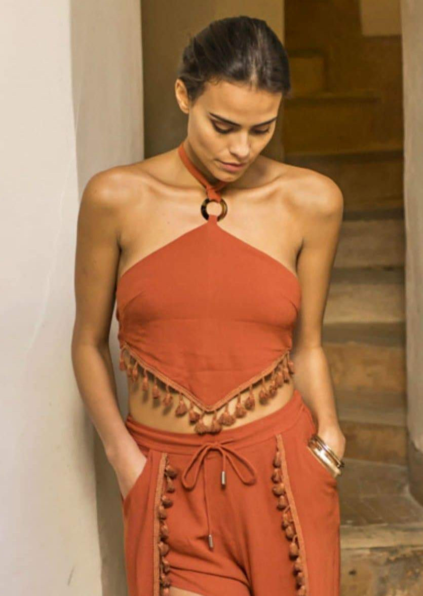 A sassy bohemian style halter top, with a tie back, and tassel trim in deep burnt orange colour.   The halter top has a feature ring detail at the front and ties at the neck.   Both elegant and sassy this top pairs well with shorts, jeans or a skirt.  S (8) M (10) L (12)