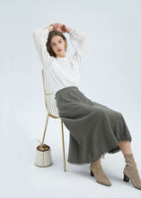 Load image into Gallery viewer, The Ada Tweed Skirt is a classic A line skirt in a beautiful Linen blend fabric, in 2 subtle earthy tones.  a mix between business and casual fashion, with a feminine and elevated approach to clothing in high-quality materials.  The Ada skirt cuts a flattering figure, styled with subtle tassels at the hem, this minimalistic GDS Ada skirt flares into a slight A-line silhouette that exudes timelessness. With a subtle gold thread detail at the waist, the Ada Tweed Skirt is understated sophistication. 
