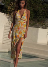 Load and play video in Gallery viewer, The Zola Halter Dress is a stunning, elegant dress in a beautiful Citrus floral print Rayon.  It features a super flattering midi length with a slit on one side, halterneck, and lovely folds around the fitted waist.  A fruity little number in a zesty citrus print that is sure to have heads turning.  Fully lined with an invisible zipper in the side seam and elasticated back.
